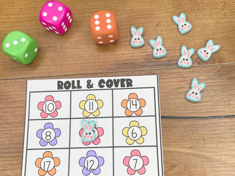 Students roll 3 dice and cover the sum in this math center.